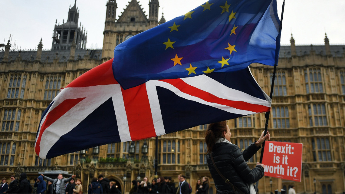 Nagy-Britannia Európai Unióból való kilépését (Brexit) ellenző tüntetők uniós (j) és brit zászlóval a kezükben a parlament épülete előtt, Londonban 2018. november 29-én.