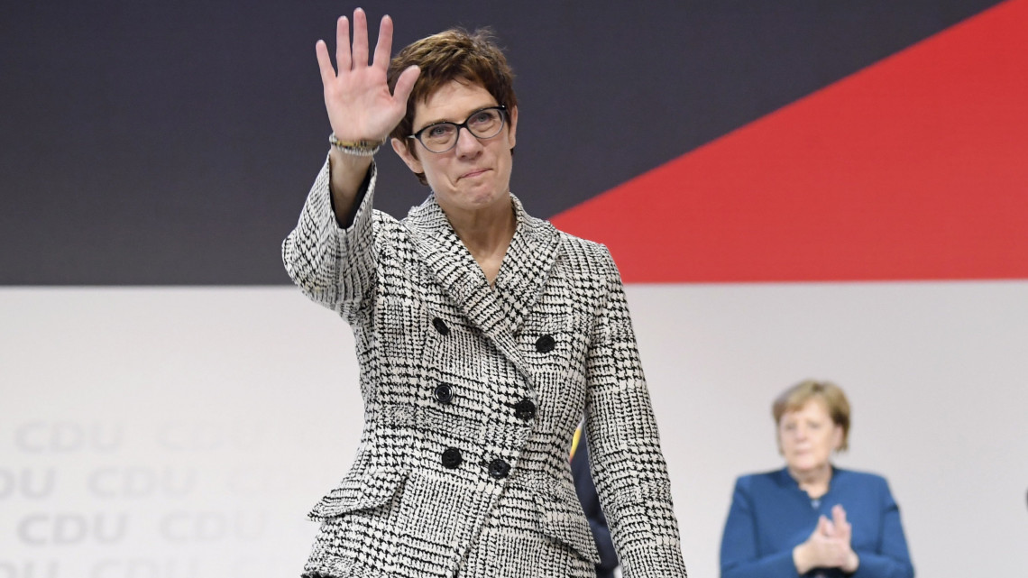 Annegret Kramp-Karrenbauer, a német Kereszténydemokrata Unió (CDU) főtitkára, miután pártelnökké választották a pártot 18. éve vezető Angela Merkel (háttérben) utódjául a CDU tisztújító kongresszusán Hamburgban 2018. december 7-én.