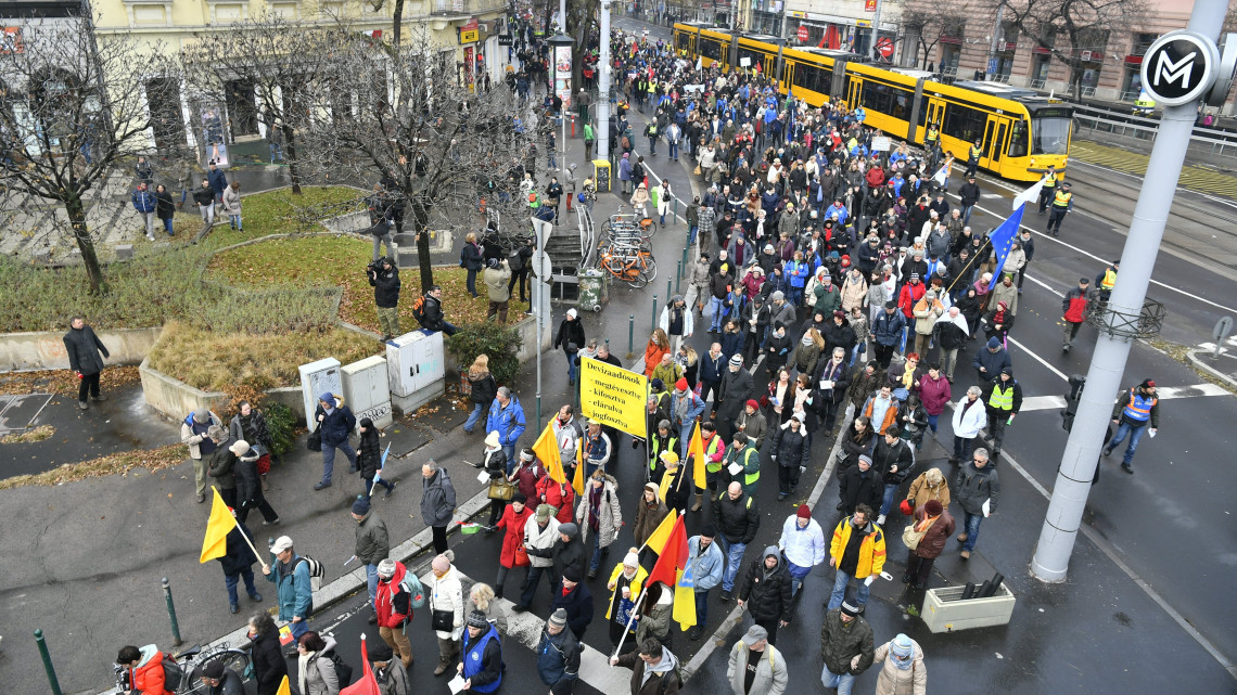 Résztvevők vonulnak a Magyar Szakszervezeti Szövetség demonstrációján a fővárosi Szent Isván körút és Bajcsy-Zsilinszky út sarkán 2018. december 8-án. A tiltakozást az évi ötven nap túlmunka ellen, a tudományos kutatási szabadságáért és a tanszabadságért tartották. A demonstrációhoz számos szakszervezet és szakszervezeti szövetség csatlakozott.