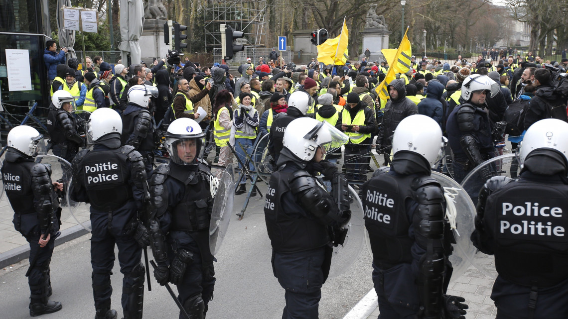 Rohamrendőrök a dráguló üzemanyagárak ellen tiltakozó sárga láthatósági mellényt viselő tüntetők előtt Brüsszelben 2018. december 8-án.
