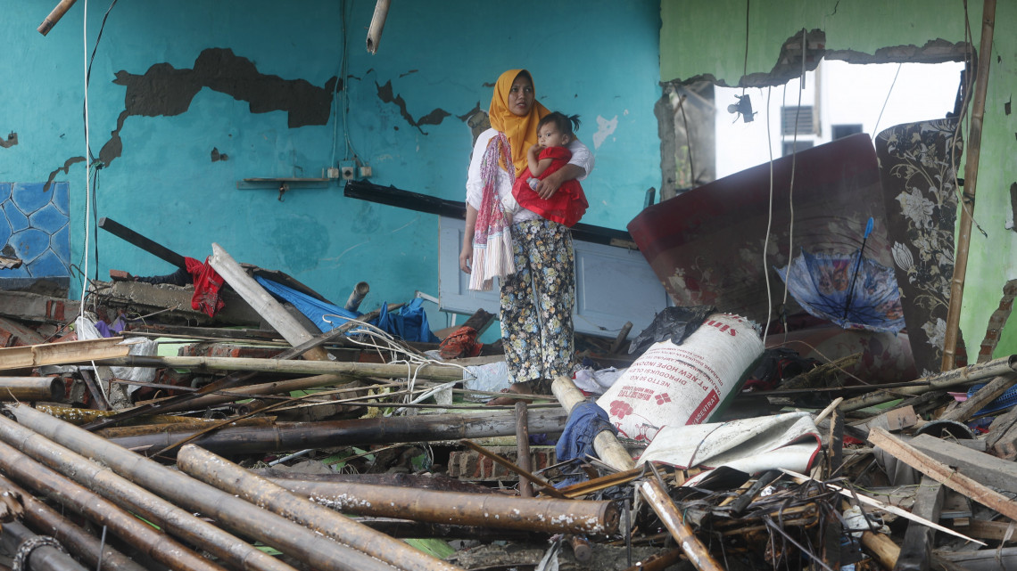 Romok között egy nő gyermekével az indonéziai Tanjung Lesungban 2018. december 24-én, két nappal a Jáva és Szumátra szigetek közötti Szunda-szoros térségében, Banten és Lampung tartományokban keletkezett szökőár után. A katasztrófa következtében legalább 281 ember életét vesztette, 57 eltűnt és több mint 1000 megsérült.