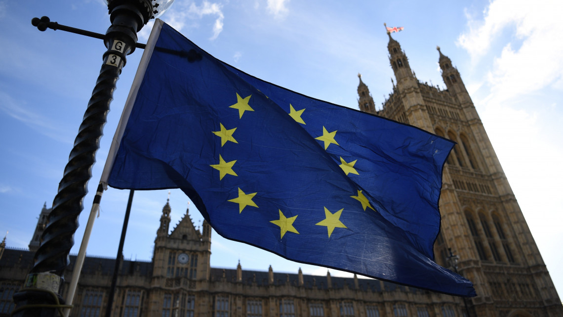 Az Európai Unió zászlaja a brit parlament épülete előtt 2018. október 18-án. Theresa May brit miniszterelnök az EU-tagországok állam- és kormányfőinek brüsszeli csúcstalálkozója második napi tanácskozása előtt úgy nyilatkozott, hogy elképzelhetőnek tartja az országa uniós kilépését követő, eredetileg 2020 végéig tervezett átmeneti időszak néhány hónapos meghosszabbítását.