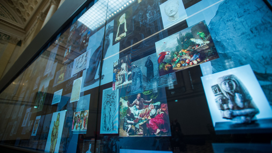 A világ legnagyobb, érintőképernyős múzeumi LCD fala a Szépművészeti Múzeum Márvány csarnokában az eszköz átadásának napján, 2019. január 22-én. A 15 méter hosszú múzeumi fal csaknem 300 műtárgy adatait jeleníti meg interaktív módon.