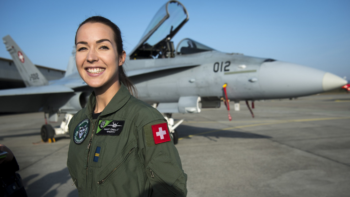 Fanny Chollet főhadnagy, a svájci légierő első női vadászpilótája egy F/A-18 Hornet (Lódarázs) harci gép előtt a svájci Payerne katonai bázison 2019. február 19-én. A 28 éves Chollet (Shotty) az első svájci pilótanő, aki kiképzését követően F/A-18-as szuperszonikus vadászgéppel, a hangsebesség felett, közel 2000 kilométer óránkénti sebességgel repülhet.