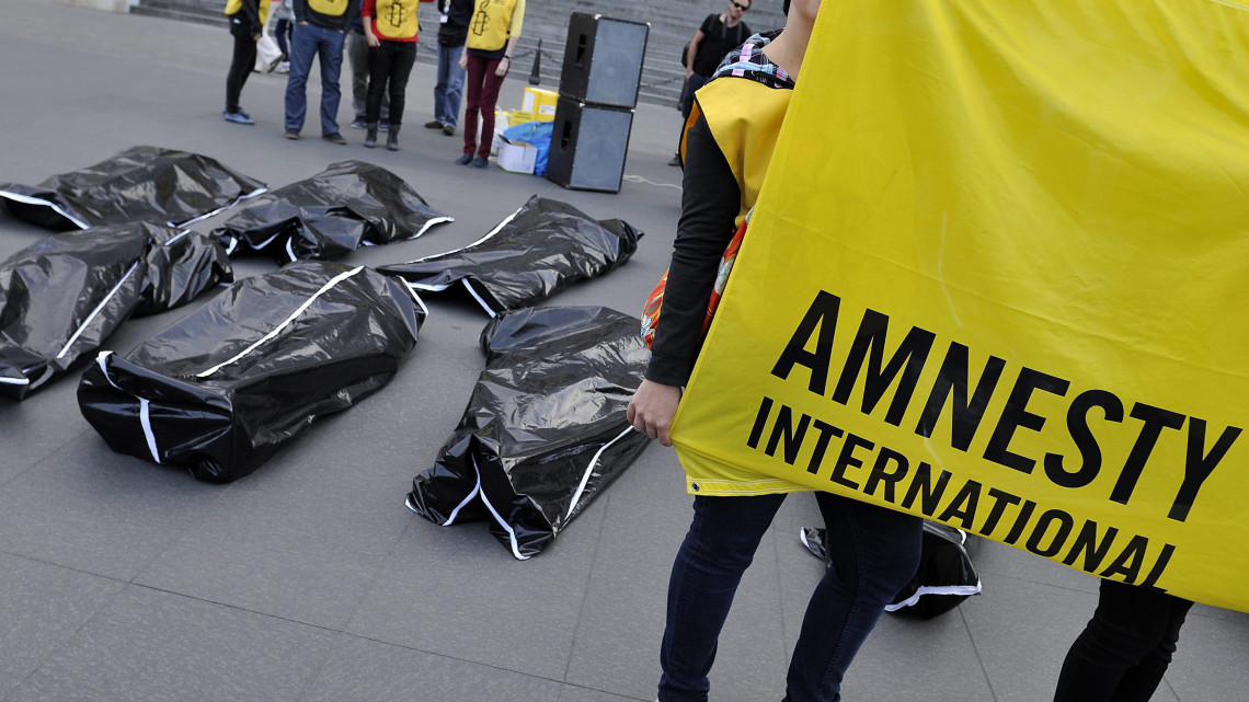 Halott menekülteket jelképező, zsákokban fekvő aktivisták az Amnesty International menekültek világnapján tartott rendezvényén a budapesti Kossuth téren 2015. június 20-án.