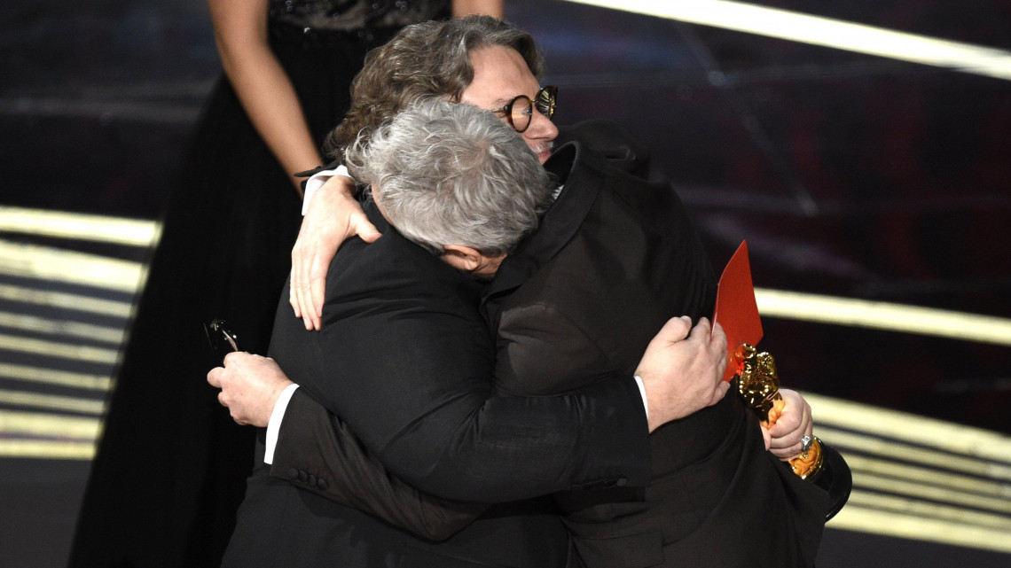 Alfonso Cuarón mexikói rendező (j) átveszi a legjobb rendezésért járó díjat Guillermo Del Toro mexikói rendezőtől a 91. Oscar-gálán a Los Angeles-i Dolby Színházban 2019. február 24-én. Cuarón a Roma című fekete-fehér drámáért kapta meg az elismerést.