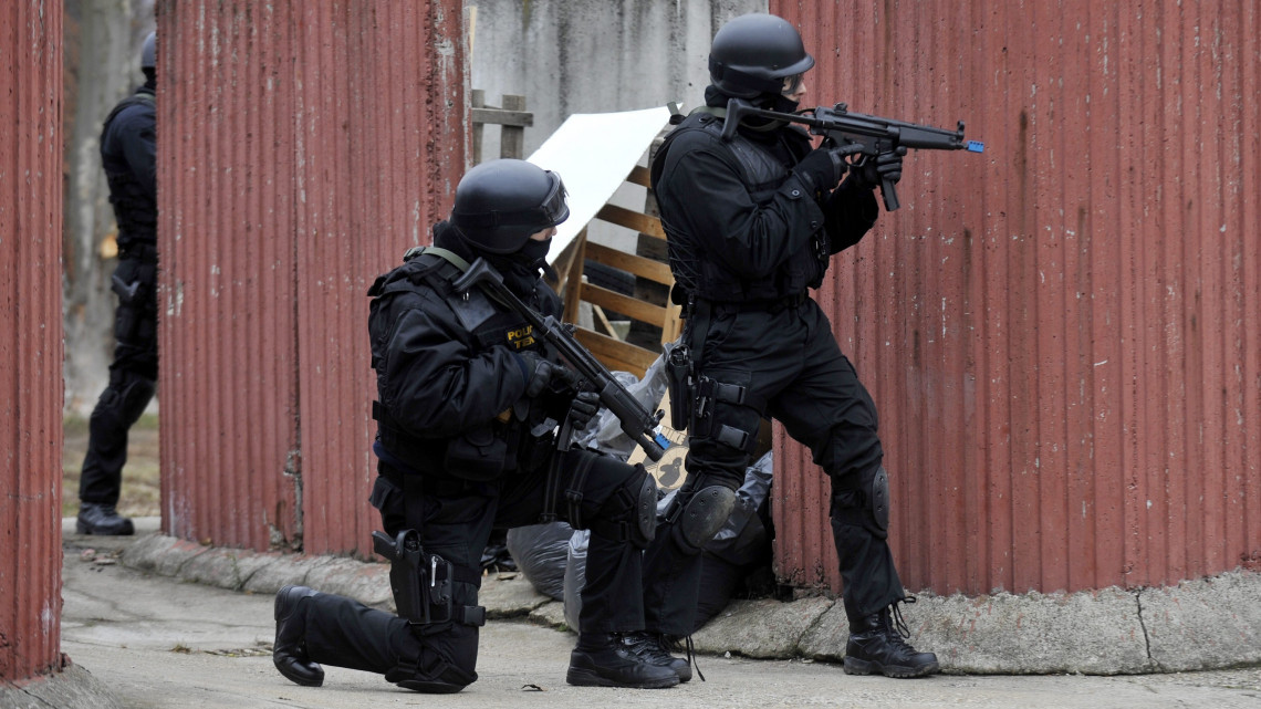 A Terrorelhárító Központ (TEK) bevetési egységének tagjai fedezék mögött bújnak Budapest X. kerületében, az Újhegyi úton, a Büntetés-végrehajtás Országos Parancsnokságának Oktatási Központja előtt, ahol egy feltételezett túszejtési gyakorlat szimulációját tartják. A gyakorlaton egy iskolai lövöldözést követő túszmentést szimuláltak kommandósok, rendőrök, mentők és tűzoltók.