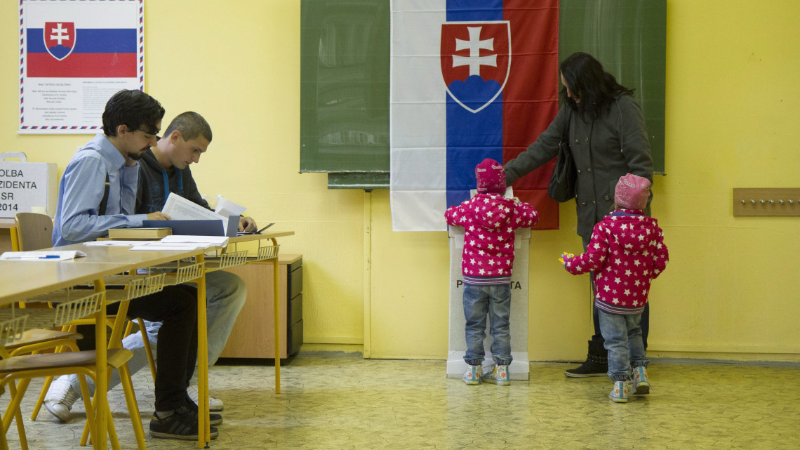 Pozsony, 2014. márcuis 15.Egy nő gyermekei társaságában leadja szavazatát egy pozsonyi szavazóhelyiségben 2014. március 15-én, a szlovák elnökválasztás napján. (MTI/EPA/Peter Hudec)