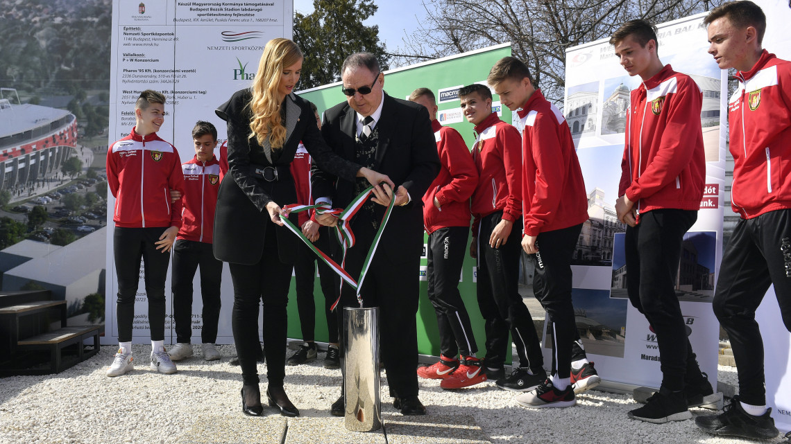 Szabó Tünde sportért felelős államtitkár és George F. Hemingway, a Budapest Honvéd labdarúgócsapat tulajdonosa az időkapszulát készülnek elhelyezni az új Bozsik Stadion alapkőletételi ünnepségén a XIX. kerületi Puskás Ferenc utcában 2019. március 21-én. Az új stadion műszaki átadására 2020. június 12-én kerül majd sor.