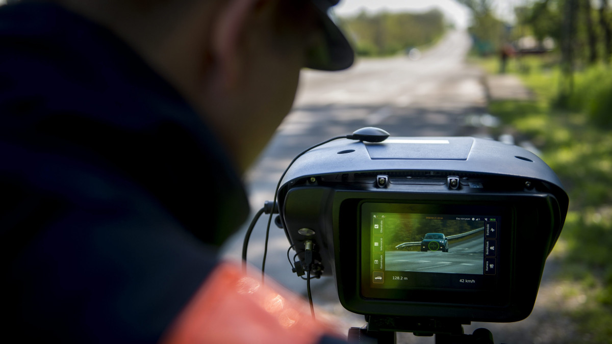 Egy rendőr a Véda automata közlekedés-ellenőrzési rendszer egyik sebességmérőjével a 6-os főúton, Pécs határában 2016. április 21-én. Csaknem kilencszáz magyarországi helyszínen ellenőrzi a rendőrség a sebességhatár túllépését reggel hat óra óta 24 órán keresztül a Speedmarathon nemzetközi akció keretében.