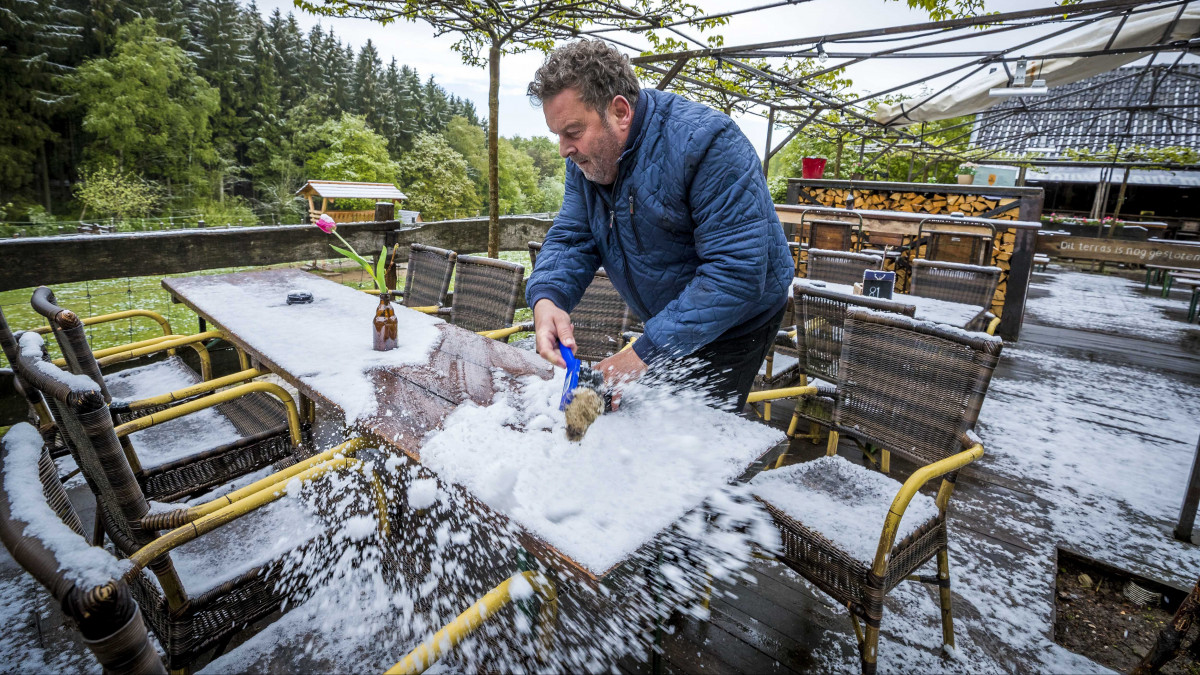 Havat takarít egy vendéglő teraszának asztalairól egy férfi a dél-hollandiai Vijlenben 2019. május 4-én. Május elején legutóbb 1979-ben esett hó Hollandiában.