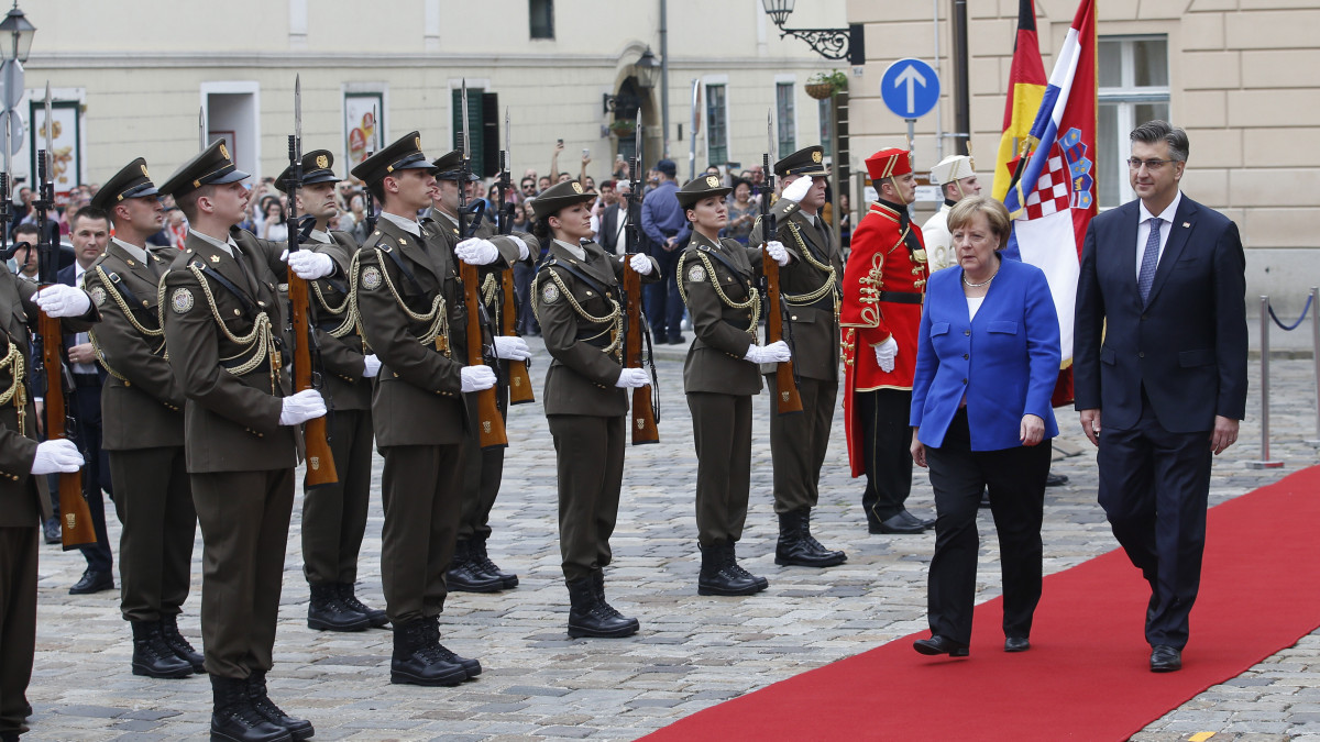 Angela Merkel német kancellár (j2) és Andrej Plenkovic horvát kormányfő (j) ellép adíszegység előtt Merkel fogadási ünnepségén Zágrábban 2019. május 18-án.