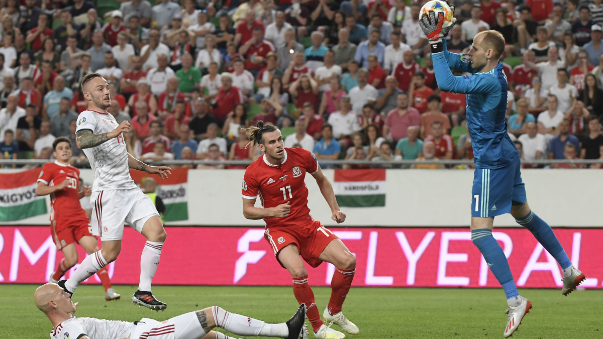 Gulácsi Péter (j) védi Gareth Bale (k) lövését, mellettük Lovrencsics Gergő (b2) és Baráth Botond (elöl) a Magyarország - Wales Európa-bajnoki selejtezőmérkőzésen a budapesti Groupama Arénában 2019. június 11-én. A magyar labdarúgó-válogatott 1-0-ra győzött.