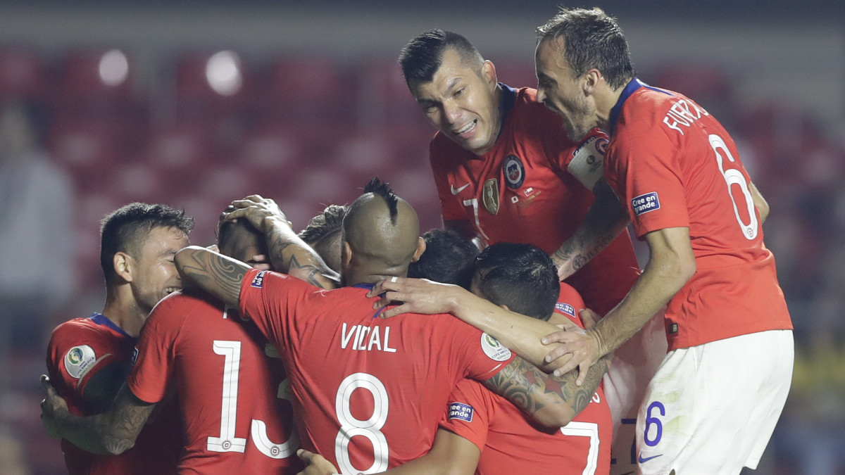 A chilei Erick Pulgar csapattársaival ünnepli gólját a Brazíliában zajló Copa America csoportkörében, a C csoport első fordulójában játszott Chile - Japán mérkőzésen Sao Paulóban 2019. június 17-én. A címvédő chilei válogatott 4-0-ra győzött. A tíz dél-amerikai együttes mellett hagyományosan két meghívott szerepel a tornán, az ázsiai válogatott mellett ezúttal Katar a másik vendégcsapat.