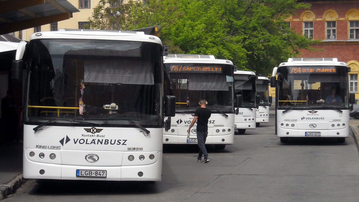 Egy férfi tart az egyik autóbusz felé a Volánbusz Zrt. Széna téri autóbusz végállomásán, ahol a helyközi járatokon közlekedő autóbuszok várnak az indulásra. Jobbra az egyik autóbusz éppen elindul a főváros-környéki településekre. MTVA/Bizományosi: Jászai Csaba  *************************** Kedves Felhasználó!