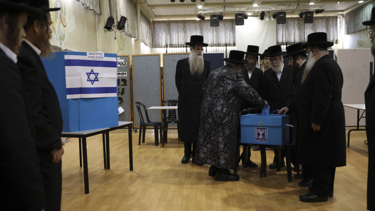 Ultraortodox zsidó férfiak nézik, amint Jiszráél Hager rabbi (k) leadja szavazatát az előrehozott izraeli parlamenti választáson Bnei Brakban 2019. szeptember 17-én. Az áprilisi választást azért kell megismételni, mert Benjámin Netanjahu nem tudta felállítani új kabinetjét a kitűzött határidőig.