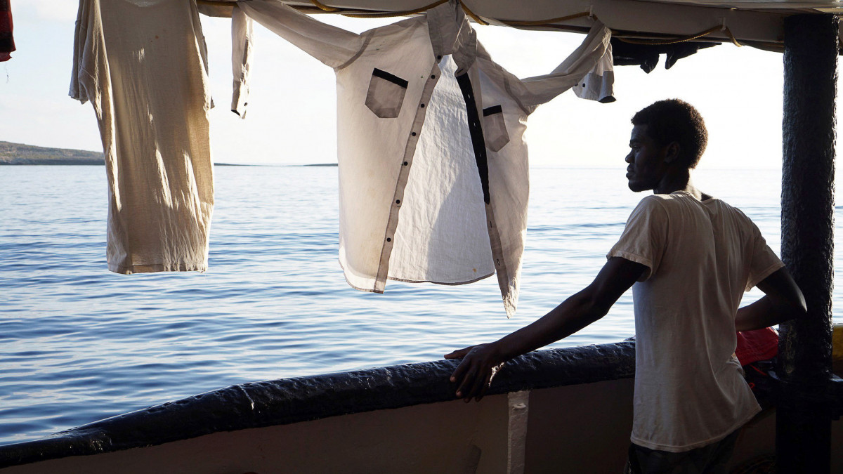 Az illegális bevándorlók egyike a dél-olaszországi Lampedusa közelében veszteglő Open Arms nevű spanyol civil mentőhajó fedélzetén 2019. augusztus 18-án. Előző nap este 27 kísérő nélküli kiskorú partra szállását engedélyezte Matteo Salvini olasz belügyminiszter. A mentőhajón még összesen 107 bevándorló maradt, akik több mint két hete várják sorsuk rendeződését.