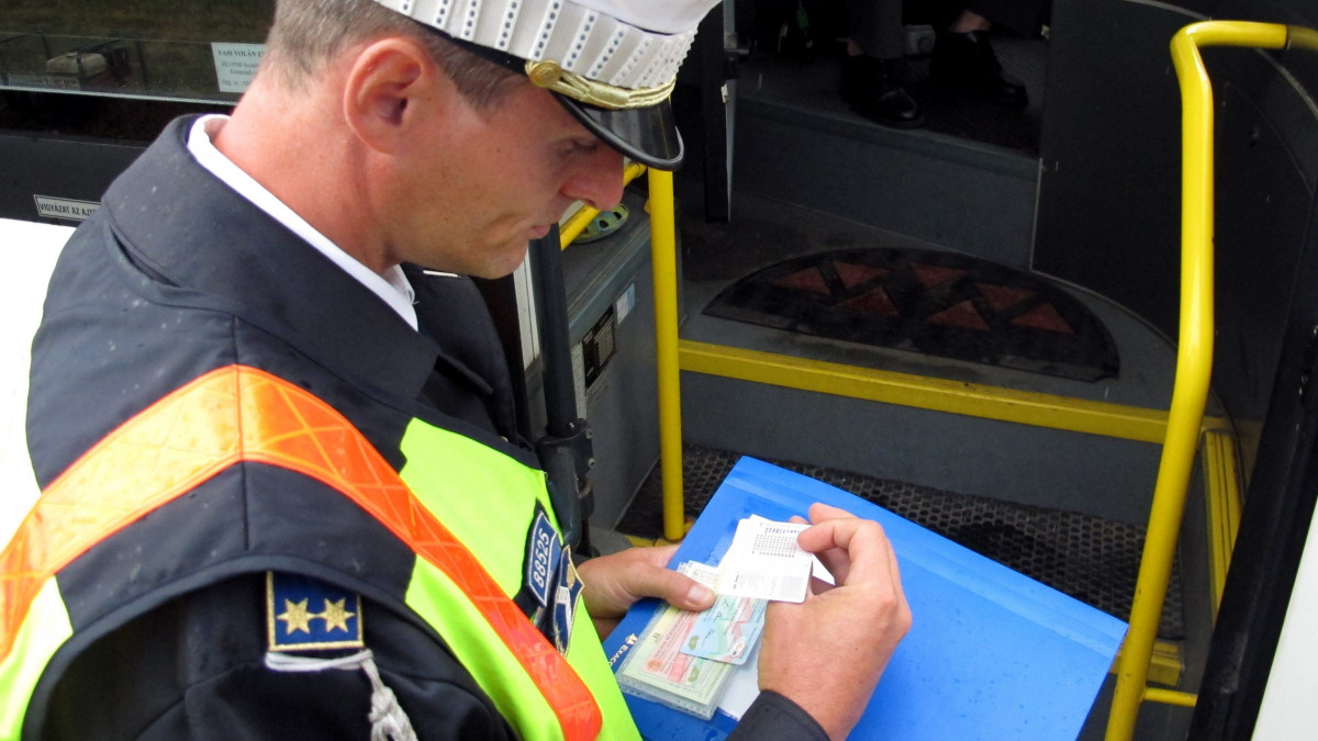 A Vas Megyei Rendőr-főkapitányság dolgozója egy busz vezetőjének papírjait ellenőrzi a 86-os és a 87-es főút közös elkerülő szakaszán. A közlekedési akció végrehajtásának kiemelt feladata az autóbuszok és tehergépkocsik közúti közlekedésével kapcsolatos szabályok ellenőrzése, mely a járművekre és a vezetőikre egyaránt kiterjed.
