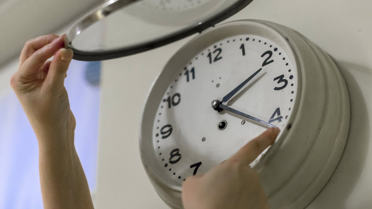 Egy nő átállítja faliórájának mutatóit 2018. október 27-én. A téli időszámítás október 28-án hajnali 3 órakor kezdődik, az órákat akkor hajnali 2 órára kell visszaállítani.