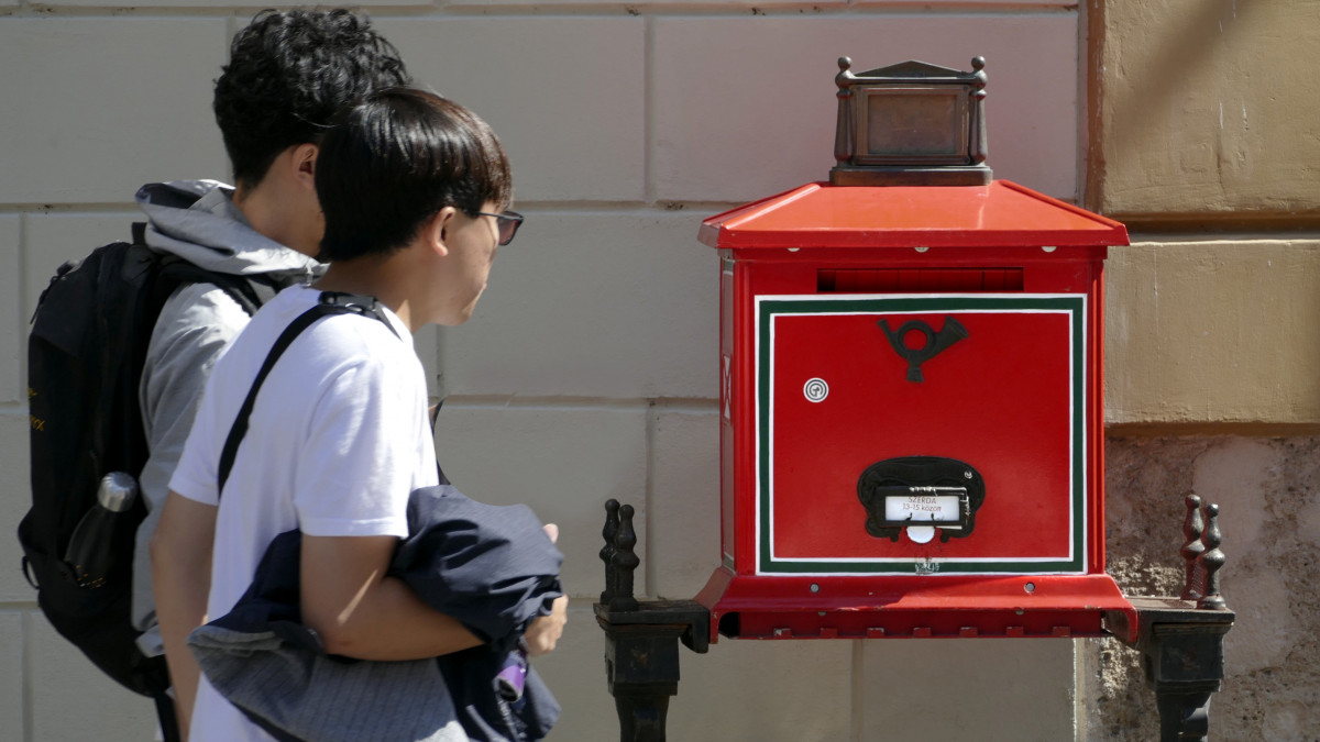 Japánból érkezett turista fiatalok érdeklődve nézik a Magyar Posta Zrt. egyik levélgyűjtő postaládáját a Budai Vár Táncsics Mihály utcájában. MTVA/Bizományosi: Jászai Csaba  *************************** Kedves Felhasználó!