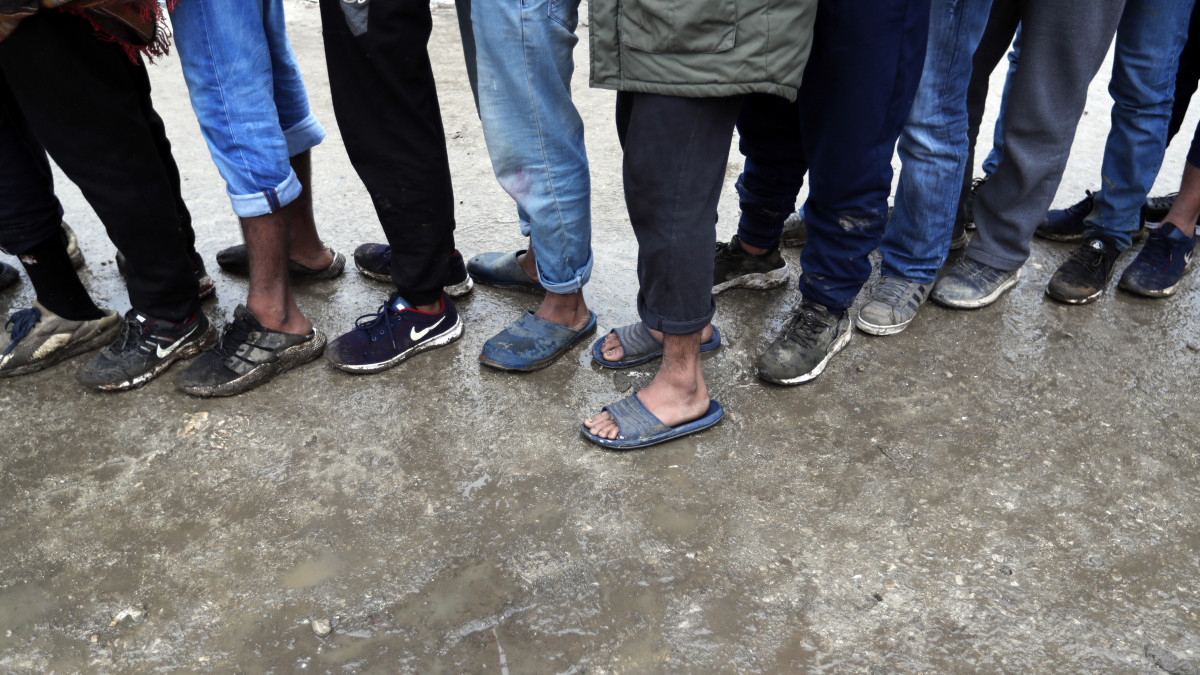 A vöröskereszt által osztott élelemért állnak sorban migránsok a Bosznia északnyugati részén, Bihac közelében lévő vucjaki befogadótáborban 2019. november 14-én. Dimitrisz Avramopulosz, az Európai Bizottság migrációs politikáért és uniós belügyekért felelős tagja szerint humanitárius válság van az Bosznia-Hercegovinában, különösen a Bihac közelében található menekülttáborban.