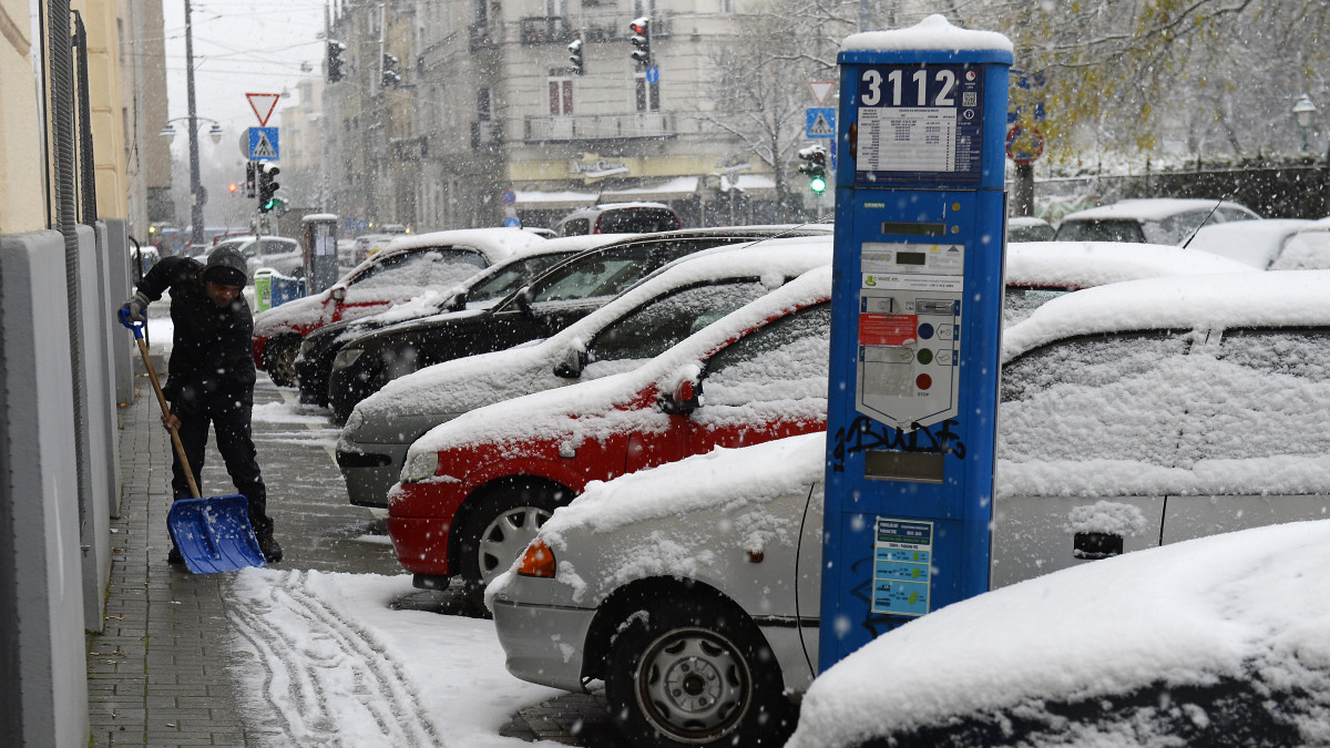 Havat lapátol egy férfi a behavazott XI. kerületi Fadrusz utcában 2019. december 2-án.