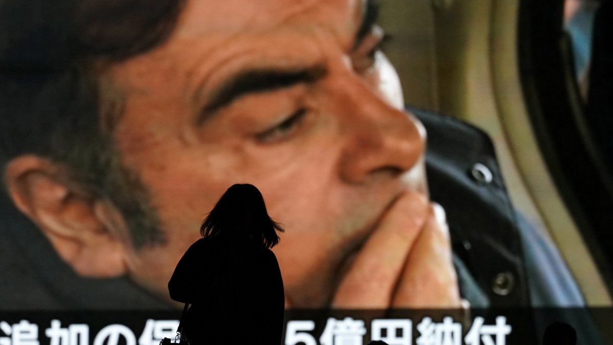 A Japánban pénzügyi visszaélésekkel vádolt Carlos Ghosnról, a Nissan járműgyártó cég leváltott elnökéről szóló híradást néznek emberek egy óriási kivetítőn Tokióban 2019. április 25-én. A leváltott Nissan-vezér ügyében az illetékes japán bíróság ezen a napon 500 millió jen, vagyis mintegy 1,3 milliárd forint óvadékot állapított meg.