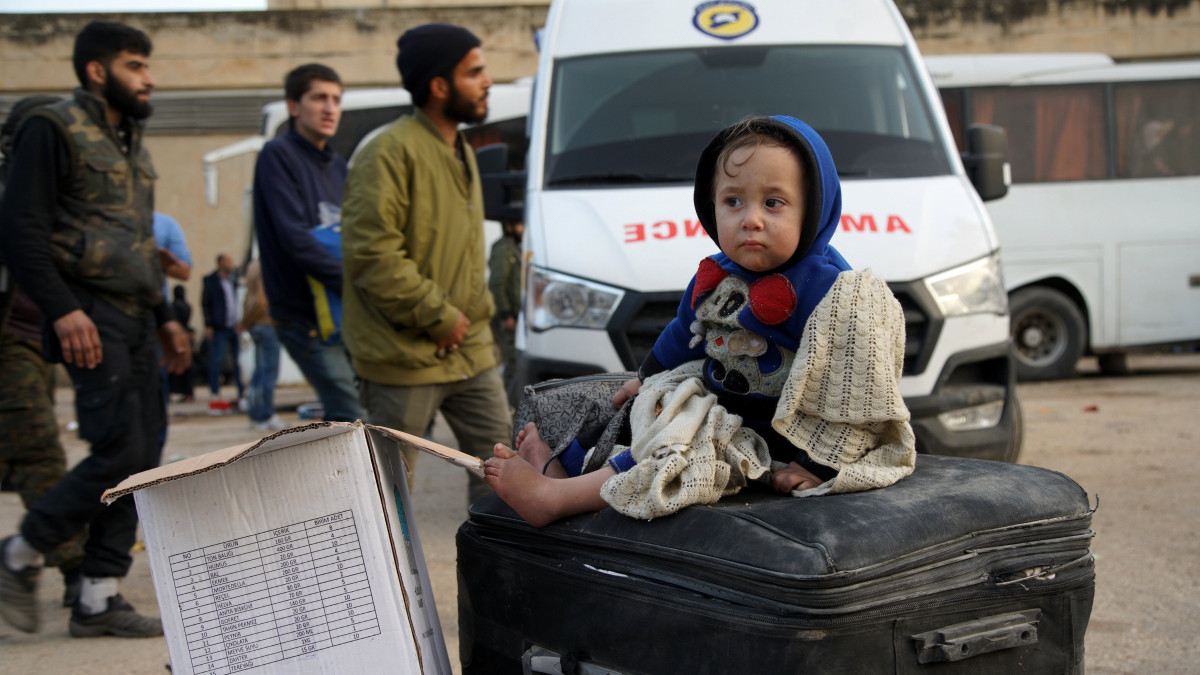 Kalat al-Madik, 2018. március 23.Bőröndön ül egy evakuált szíriai kisgyerek, miután megérkezett a nyugat-szíriai Hamá kormányzóságban fekvő Kalat al-Madik városba 2018. március 23-án. A napokban a szíriai kormány és az Ahrár as-Sám lázadócsoport orosz közreműködéssel megegyezett abban, hogy a harcosok leteszik a fegyvert a kelet-gútai Harasztában, cserébe a fegyveresek és polgári lakosok szabadon elhagyhatták a települést a kormányerők biztosította buszokkal. (MTI/EPA/Jahja Nemah)