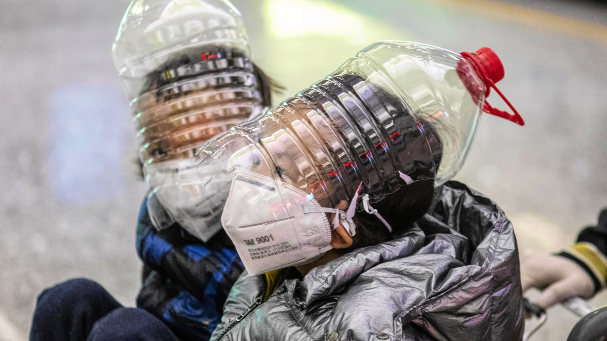 Műanyag palackból készített arcmaszkot viselnek gyerekek a Kuangtung tartománybeli Kuangcsouban (Kanton) repülőterén 2020. február 1-jén. Az új koronavírus eddig csaknem 12 embert fertőzött meg Kínában, a halottak száma pedig elérte a 259-et Kínában, valamint szórványos eseteket jelentettek több mint 20 országból.