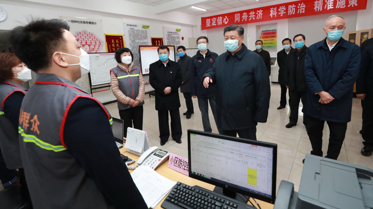 Hszi Csin-ping kínai elnök (k) az új koronavírus járvány terjedésének megakadályozására tett intézkedésekről tájékozódik Peking egyik kerületében 2020. február 10-én.