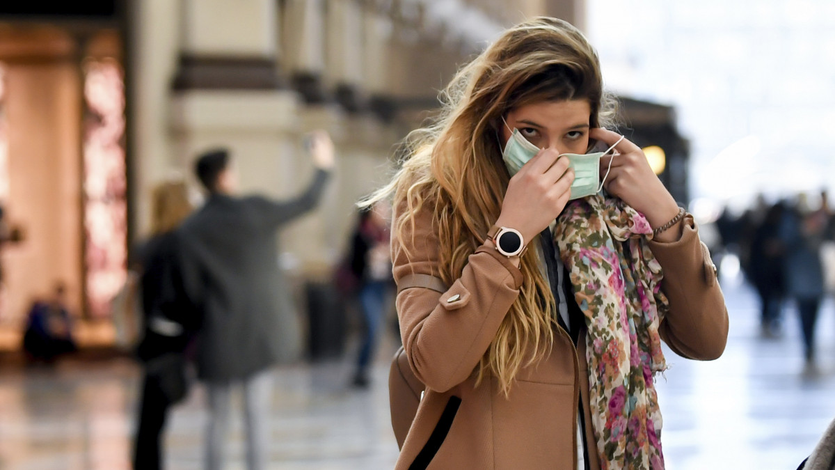 Egészségügyi maszkját igazítja meg egy járókelő Milánóban 2020. február 24-én. Az osztrák hatóságok az előző nap felfüggesztették a vasúti átkelést az Olaszországgal közös határon, miután a Velencéből induló, Münchenbe tartó nemzetközi  járatok egyikén az új koronavírus fertőzés tüneteit állapították meg két utasnál. Olaszországban 160-ra emelkedett a tüdőgyulladást okozó vírussal fertőzöttek száma, és hatan veszítették életüket. A halálos áldozatok mindannyian idős, más betegségben is szenvedő emberek voltak.