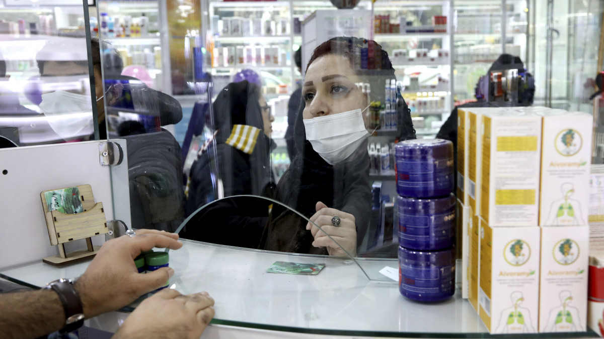 Védőmaszkot viselő vásárló egy teheráni gyógyszertárban 2020. február 25-én. Kínán kívül eddig Iránban haltak meg a legtöbben a tüdőgyulladást okozó új koronavírustól, legkevesebb tizenhatan. A bizonyítottan a koronavírustól fertőzöttek száma egy nap alatt 35-tel 95-re emelkedett, a fertőzésgyanús esetek száma mintegy 900.