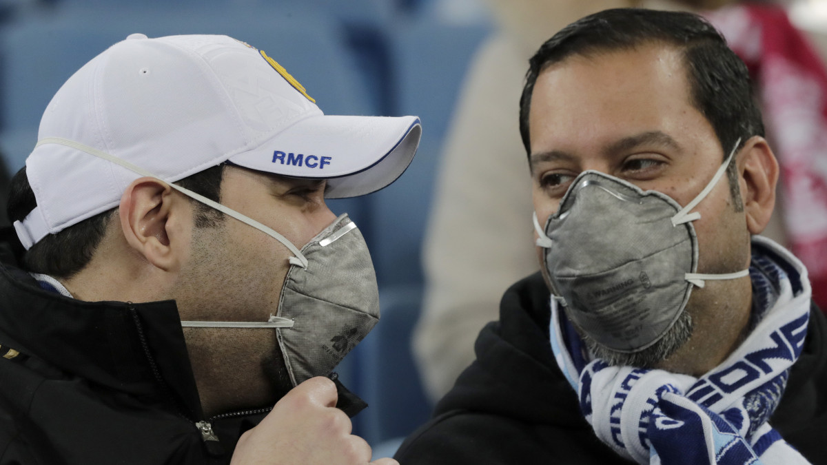 Szurkolók maszkot viselnek a tüdőgyulladást okozó új koronavírus-járvány ellen a labdarúgó Bajnokok Ligája nyolcaddöntőjében játszott Real Madrid - Manchester City első mérkőzésen a madridi Santiago Bernabeu stadionban 2020. február 26-án.