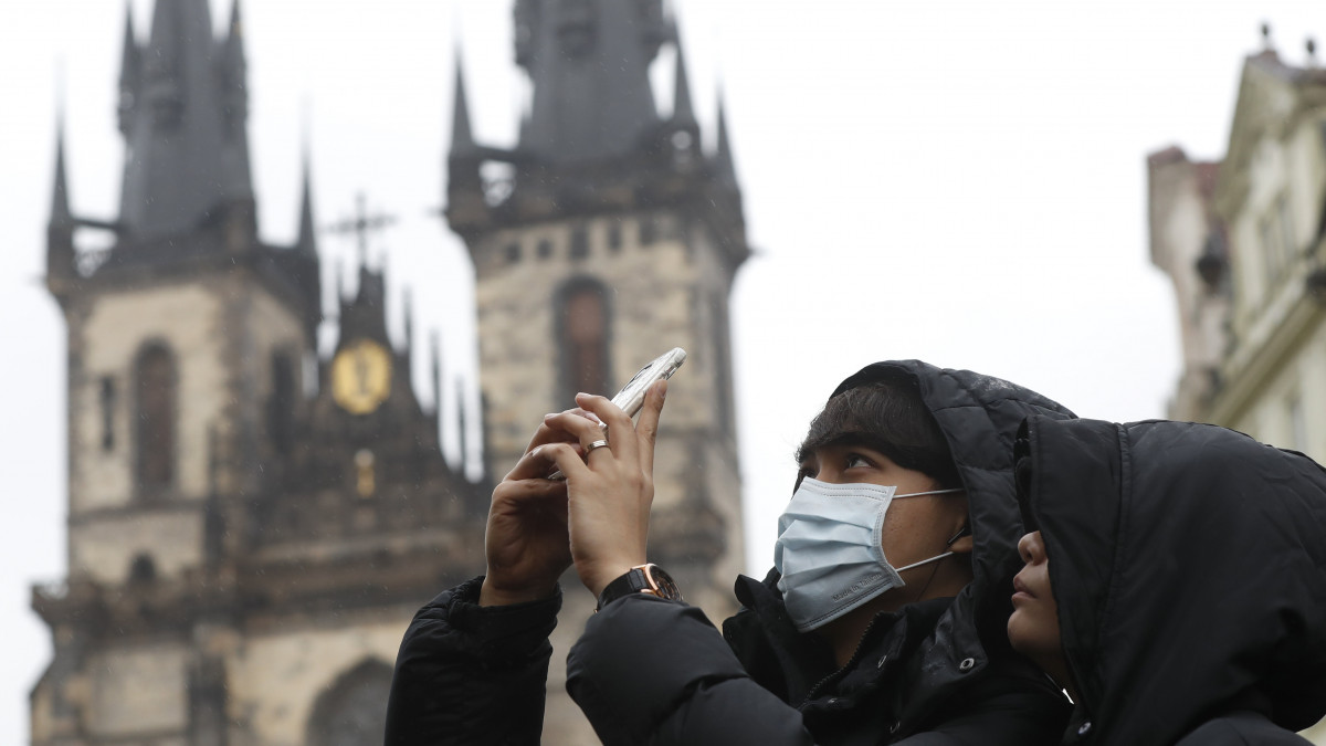 Prága, 2020. március 11.Védőmaszkot viselő férfi fényképez Prága óvárosában 2020. március 11-én. MTI/AP/Petr David Josek