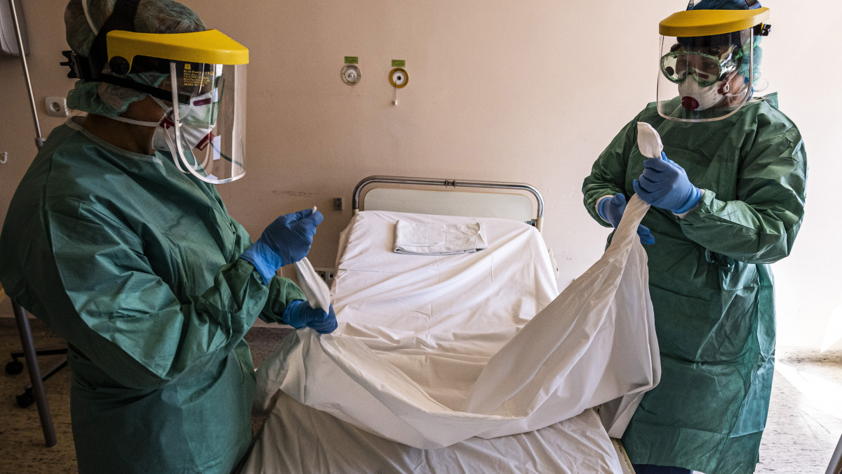 Védőfelszerelést viselő nővérek egy kórtermet készítenek elő a koronavírussal érintett új betegek fogadására kialakított egyik osztályon a fővárosi Szent László Kórházban 2020. március 16-án.