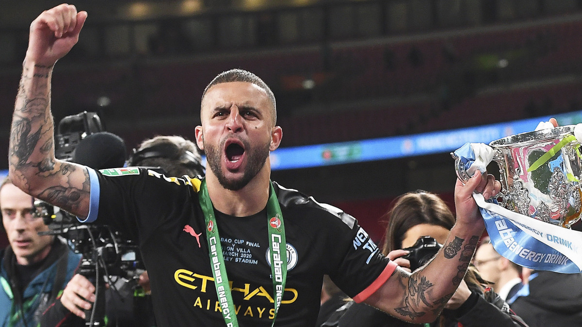 Kyle Walker (b) és John Stones, a Manchester City játékosai ünnepelnek a bajnoki trófeával, miután 2-1-re győztek az Aston Villa ellen az angol labdarúgó Ligakupa döntőjében a londoni Wembley Stadionban 2020. március 1-jén.