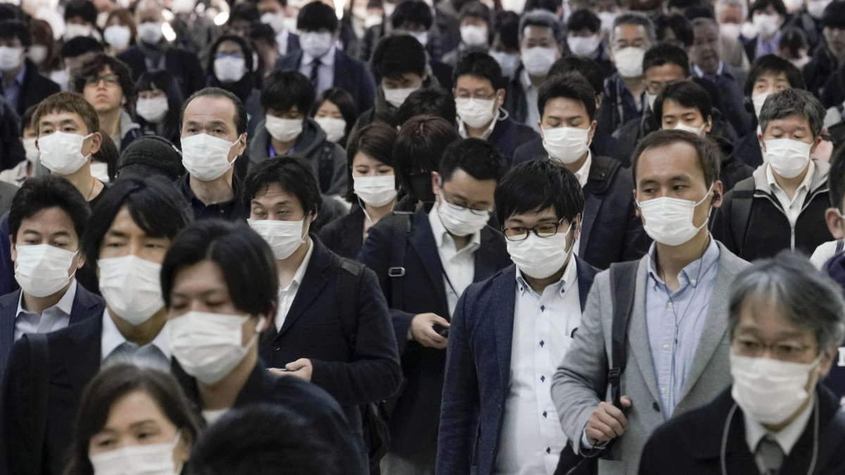 Védőmaszkos járókelők egy tokiói pályaudvaron 2020. április 6-án. Abe Sindzó japán miniszterelnök bejelentette, hogy Tokióban és hat másik prefektúrában korlátozott kijárási tilalmat vezetnek be a koronavírus-járvány elleni védekezéképpen.