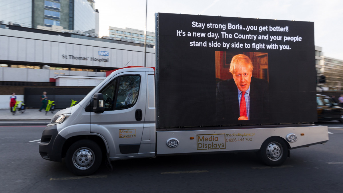 Boris Johnson brit miniszterelnököt támogató üzenet egy kisteherautó oldalán a londoni St. Thomas Kórház előtt 2020. április 7-én. Az új koronavírussal fertőzött kormányfőt az előző este átszállították a londoni St. Thomas Kórház intenzív osztályára, és akadályoztatása alatt Dominic Raab külügyminiszter látja el a kormányfői feladatokat.