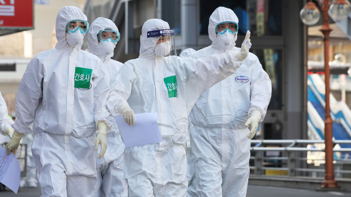 Az új típusú koronavírus terjedése miatt védőruhába öltözött dél-koreai orvosok érkeznek munkába a tegui Tong Szan kórházban 2020. március 24-én. Dél-Koreában 9037 koronavírussal fertőzött személyt tartanak nyilván, a halálesetek száma 120-ra nőtt.