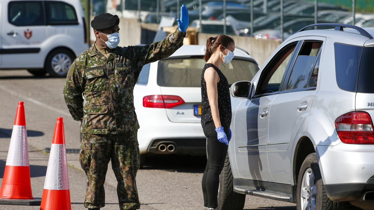 Katonák védőmaszkot osztanak a luxembourgi Findel Repülőtérnél 2020. április 17-én. A luxemburgi kormány döntésének értelmében a koronavírus-járvány miatt elrendelt korlátozások után április 20-tól újra termelni kezdő ipari vállalatok minden dolgozója térítésmentesen kap egy öt arcmaszkból álló készletet, és az első szakaszban a kiosztást a hadsereg szervezi meg.