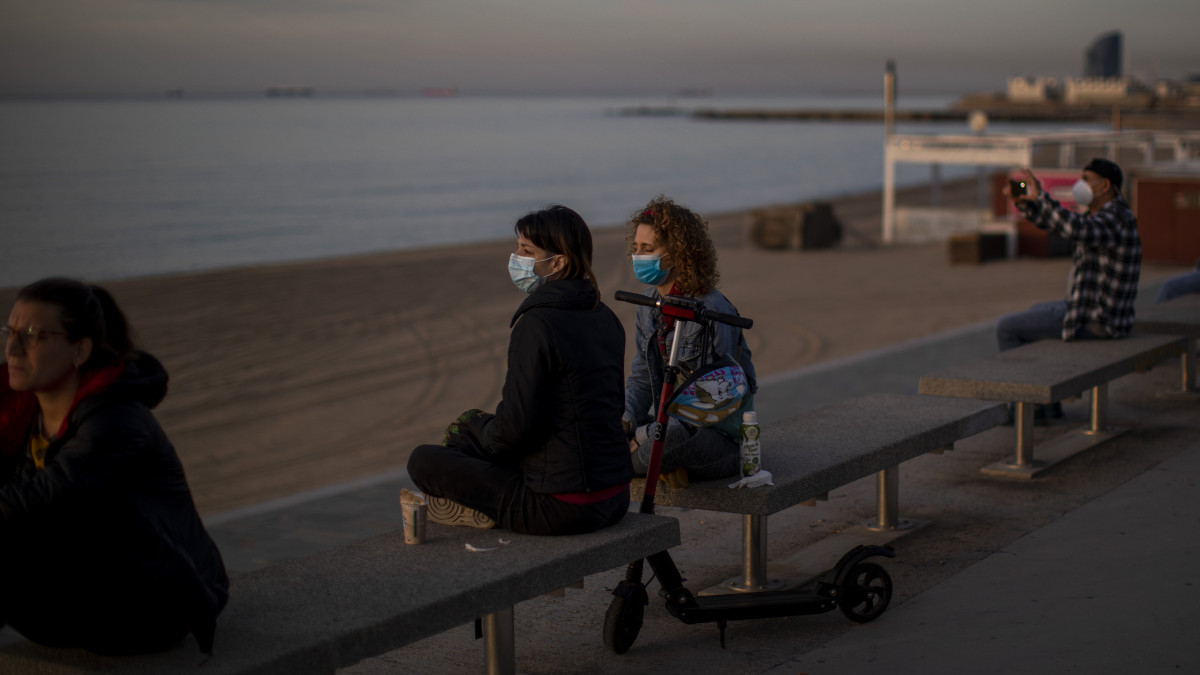 A barcelonai tengerparti sétányon, a Barcelonetán ülnek emberek 2020. május 3-án, miután az előző nap a kormány enyhített a koronavírus-járvány miatt elrendelt kijárási korlátozáson Spanyolországban.