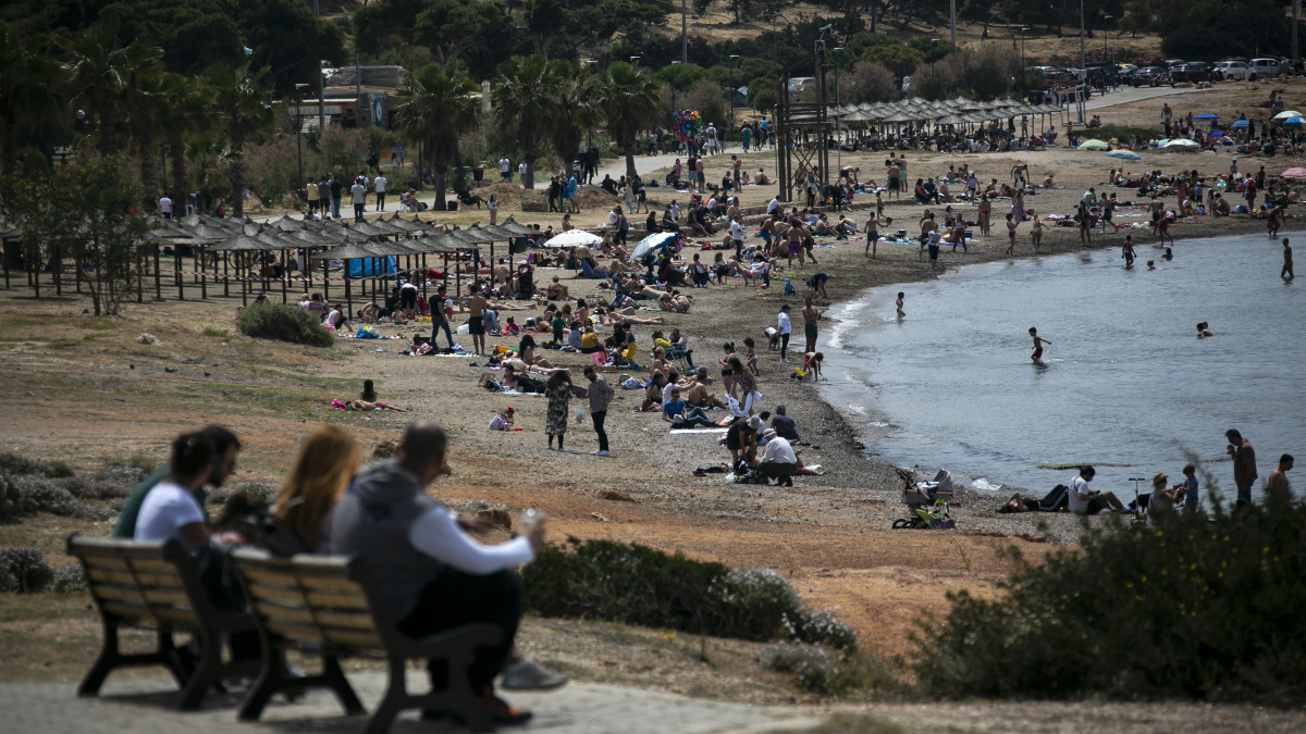 Napozó és sportoló emberek Athén Glifáda nevű elővárosának tengerpartján 2020. május 10-én. Görögországban elkezdték a koronavírus-járvány miatt bevezetett korlátozások fokozatos feloldását, de a bárok és éttermek még nem nyithatnak ki.