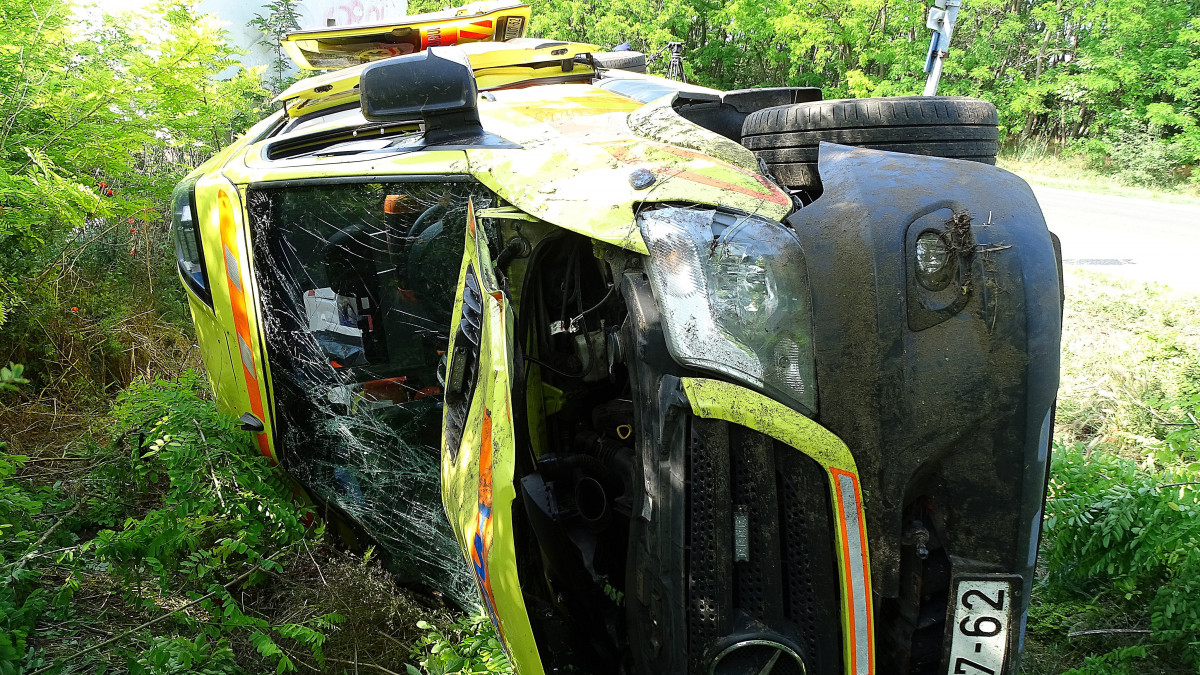 Felborult mentőautó az 5-ös főúton Lajosmizsénél, miután a balesethez tartó, megkülönböztető jelzést használó mentő személyautóval ütközött össze 2020. június 8-án. A mentők két embert kórházba vittek.