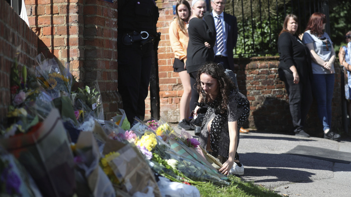 Virágokat helyez el egy gyászoló az angliai Wokingham egyik iskolája előtt 2020. június 22-én. James Furlong, az iskola egyik tanára életét veszítette a readingsi Forbury Gardens nevű parkban, amikor egy 25 éves férfi késsel megtámadta június 20-án. A támadásban még két ember meghalt, hárman súlyosan megsebesültek. A gyilkossággal gyanúsítottat férfit őrizetbe vették.