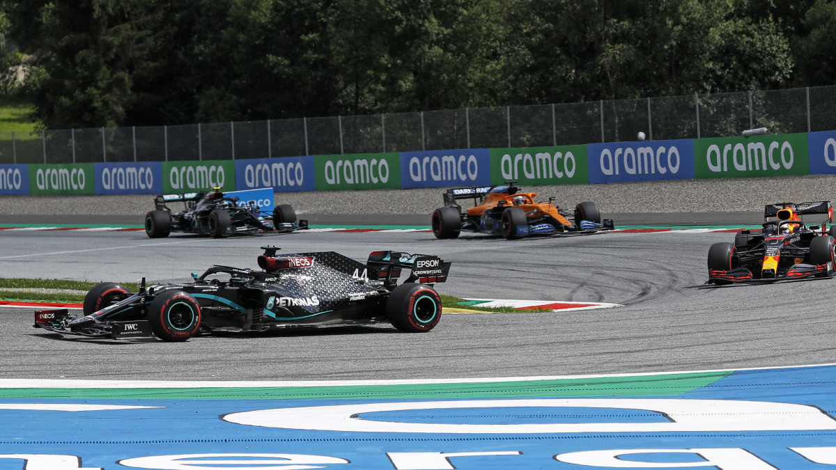Lewis Hamilton, a Mercedes brit címvédője (b) halad Max Verstappen, a Red Bull holland versenyzője (j) és Carlos Sainz Jr., a McLaren spanyol versenyzője előtt a Forma-1-es autós gyorsasági világbajnokság Stájer Nagydíján a spielbergi pályán 2020. július 12-én. A hatszoros világbajnok Hamilton az első rajtkockáról indult.