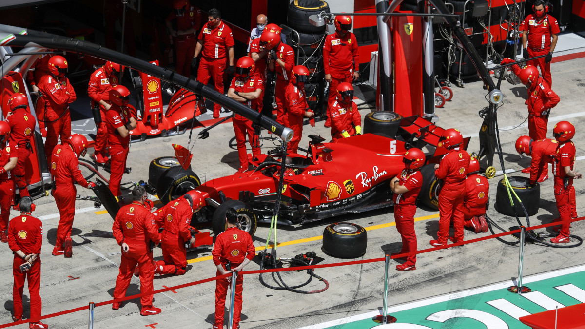 Technikusok veszik körül Sebastian Vettelnek, a Ferrari német versenyzőjének autóját a Forma-1-es autós gyorsasági világbajnokság Stájer Nagydíjának kezdete előtt a spielbergi pályán 2020. július 12-én. A Stájer Nagydíj, a 2020-as világbajnokság második futama, amely a koronavírusjárvány miatt került be utólag a törölt futamok egyikének pótlására.