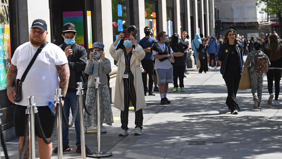 Sorban állnak a vásárlók a londoni Selfridges áruház előtt 2020. június 15-én, amikor a koronavírus-járvány miatti háromhavi zárva tartás után ismét kinyithatnak a nem létszükségleti cikkeket árusító üzletek Nagy-Britanniában.