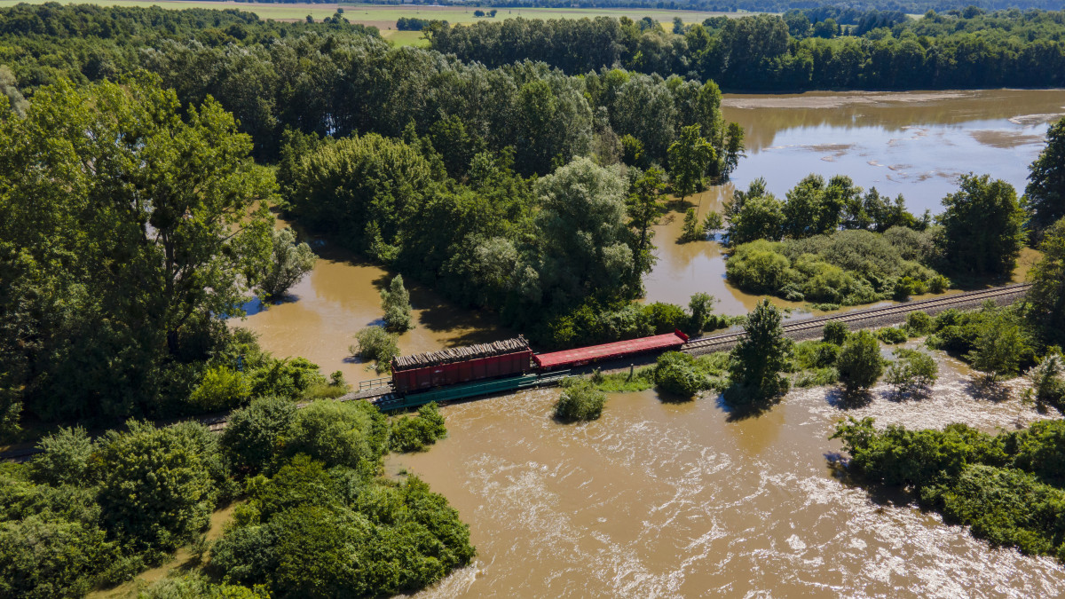 Fával megrakott vagonnal terhelik a heves esőzés miatt megáradt Rinya-patak hídját Babócsa és Péterhida között 2020. július 28-án.