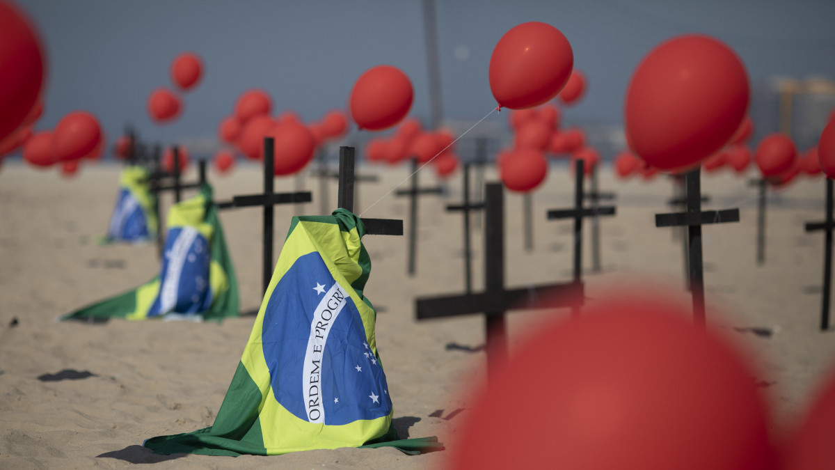 A 2020. augusztus 10-én közreadott képen kereszteket, piros léggömböket és brazil nemzeti zászlókat helyeztek el a Rio de Paz nevű civil szervezet tagjai a koronavírus-járvány áldozatainak tiszteletére a Rio de Janeiro-i Copacabana beach nevű tengerparti strand homokjában auguszus 8-án, miközben Brazíliában már több mint 100 000 ember halt a járvány miatt.