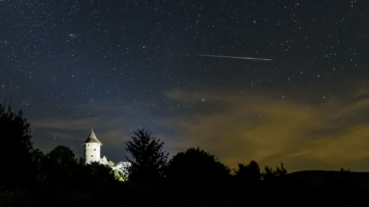 Meteor az égbolton a somoskői vár felett Salgótarjánból fotózva 2020. augusztus 11-én éjjel. A Föld belépett a Perseida meteorraj összetevőit alkotó 109P/Swift-Tuttle üstökös pályája mentén szétszórt porfelhőbe. A Perseidák az egyik legismertebb, sűrű csillaghullást előidéző meteorraj.